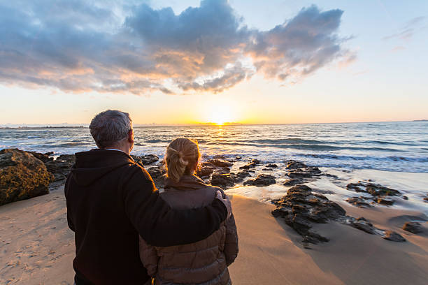 istock Couple in love watching a sunset on the beach 480344580