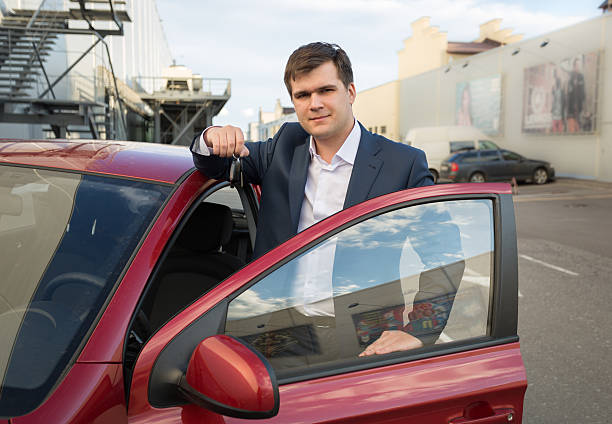 istock happy man posing with new car and showing keys 480347162