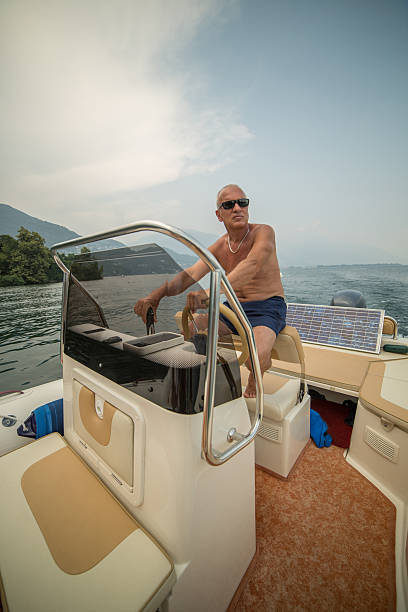 istock Mature man driving a speedboat on lake 480349120