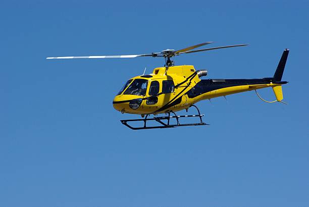 istock Yellow Helicopter in flight against brilliant blue sky 480350924
