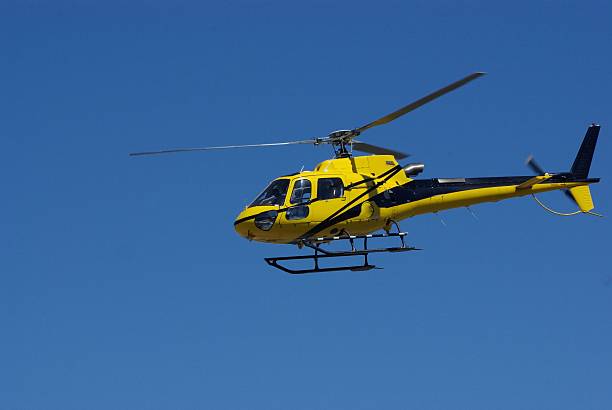 istock Yellow Helicopter in flight against brilliant blue sky 480350932