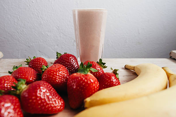 istock strawberry banana smoothie fresh blended on wood table 480353552