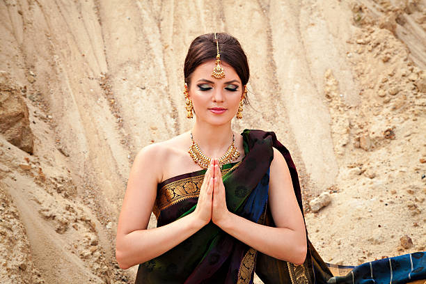 Young sensual woman in traditional indian dress Young woman in traditional indian dress against the sand background saree bridesmaid stock pictures, royalty-free photos & images