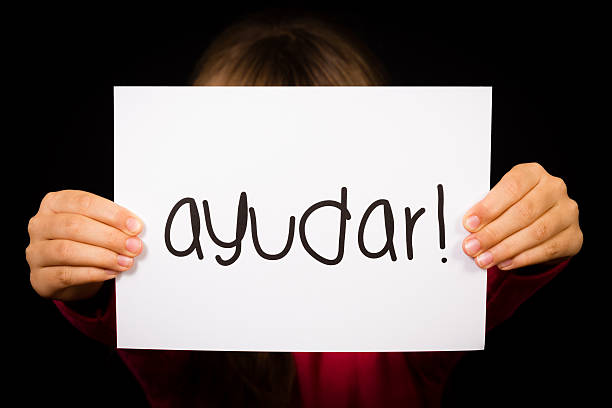 istock Child holding sign with Spanish word Ayudar - Help 480358006