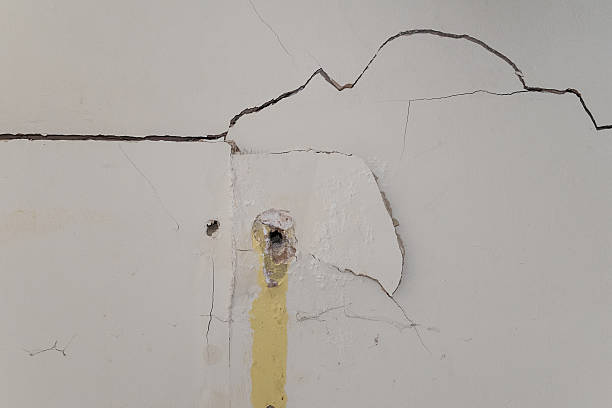 cracked plaster on interior wall badly damaged interior plasterboard wall with drill holes painted drywall texture stock pictures, royalty-free photos & images