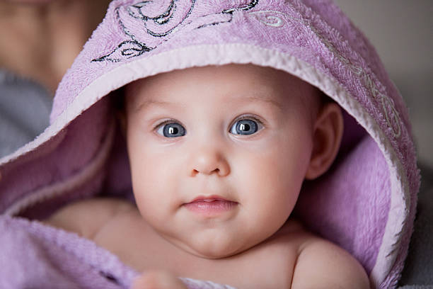 istock beautiful baby under violet bathrobe 480365159