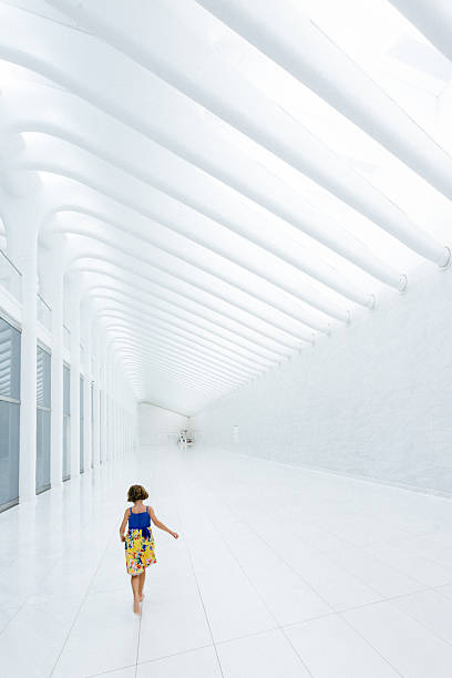 Little Girl walking barefoot on white marble corridor