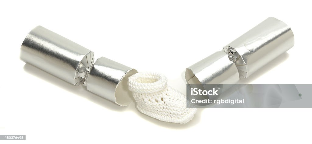 Baby Christmas cracker Spent Christmas cracker revealing a baby's knitted boot Christmas Cracker Stock Photo