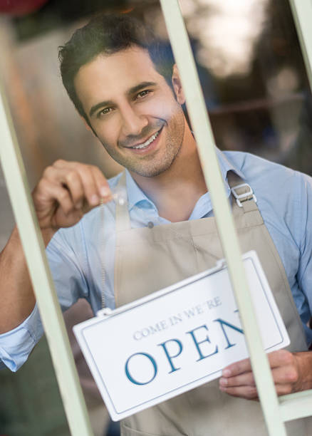 istock Business owner hanging an open sign 480379764