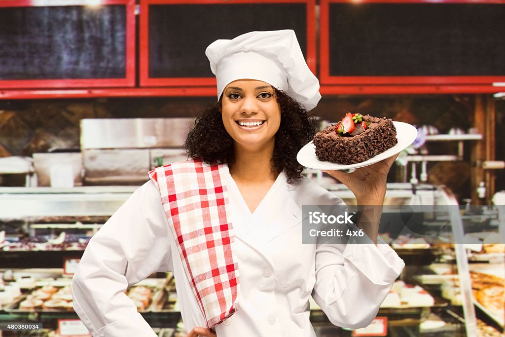 Baker carrying cake at bakery shop Baker carrying cake at bakery shophttp://www.twodozendesign.info/i/1.png 20-29 Years Stock Photo