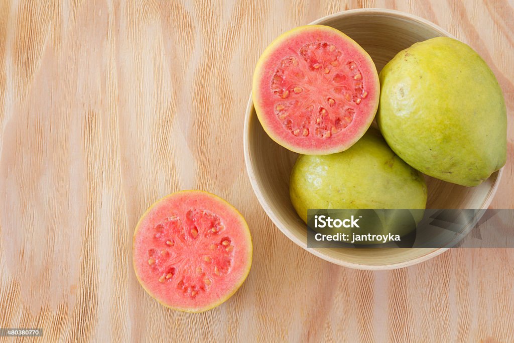 Fresh goiaba on wooden table Fresh goiaba on wooden table. Selective focus. Copy space Guava Stock Photo