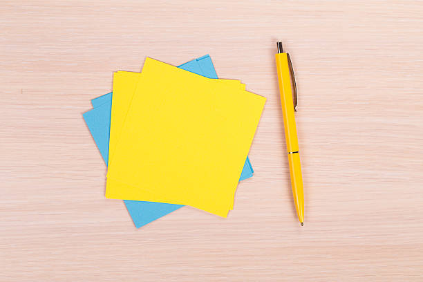 istock yellow and blue paper with pen 480381336