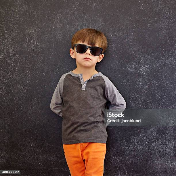 Stylish Little Boy Wearing Sunglasses Leaning On A Blackboard Stock Photo - Download Image Now