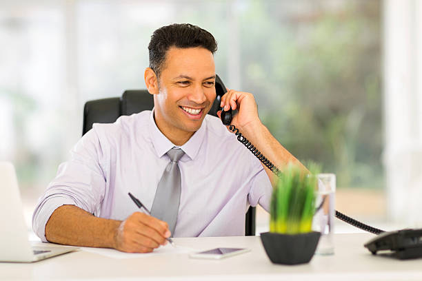 istock middle aged businessman talking on landline phone 480390478