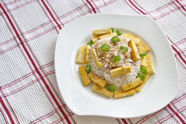 basmati rice with roasted pieces of tofu served on chequered tablecloth