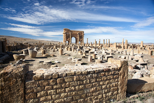 blue sky and white clouds on the Roman ruins of Timgad in Algeria, World Heritage Site by UNESCO
