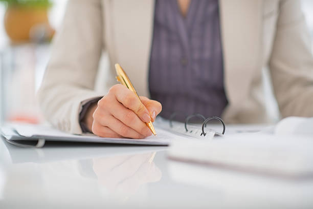 istock closeup on business woman writing in document 480400835