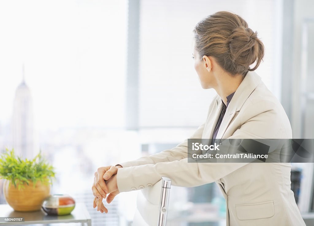 Business woman standing in office. rear view Business woman standing in office and looking in window. rear view Adult Stock Photo