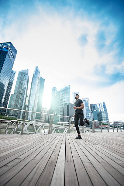 mann läuft auf die stadt von singapur marina bay area - singapore city stock-fotos und bilder