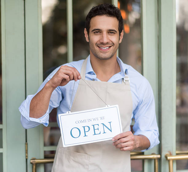 istock Manager holding an open sign outside a shop 480408262