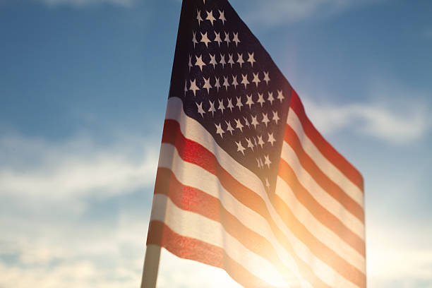 istock American Flag Against Blue Sky 480408278