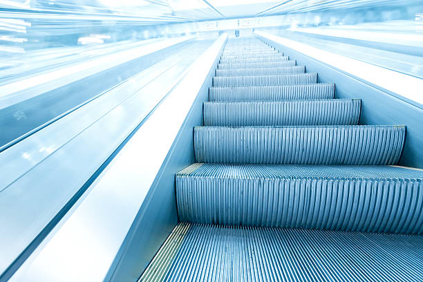 istock advanced business way, blue diminishing escalator inside contemporary airport 480408409