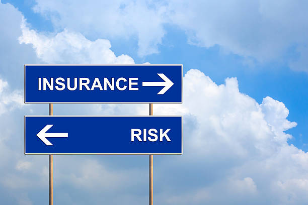 Insurance and risk on blue road sign stock photo