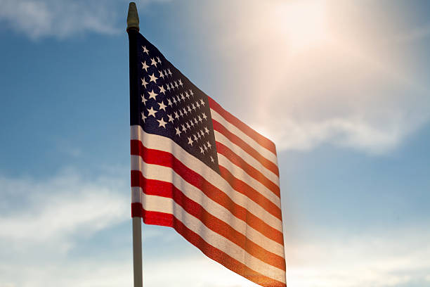 istock American Flag Against Blue Sky 480415312