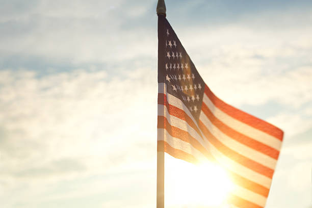 istock American Flag Against Blue Sky 480415316