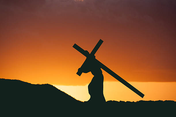 istock Christ in the sunset carrying his cross. 480416668