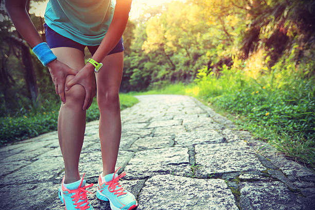 frau läufer halten ihr knie sport verletzt - schmerz stock-fotos und bilder