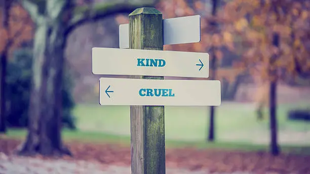 Photo of arrows pointing two opposite directions towards Kind and Cruel