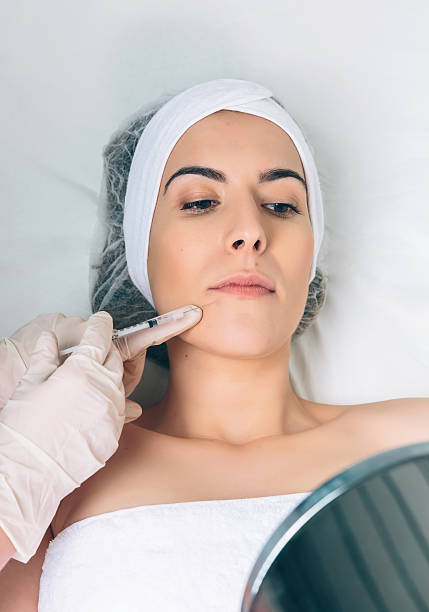 istock Pretty woman looking lips treatment in a mirror 480426450