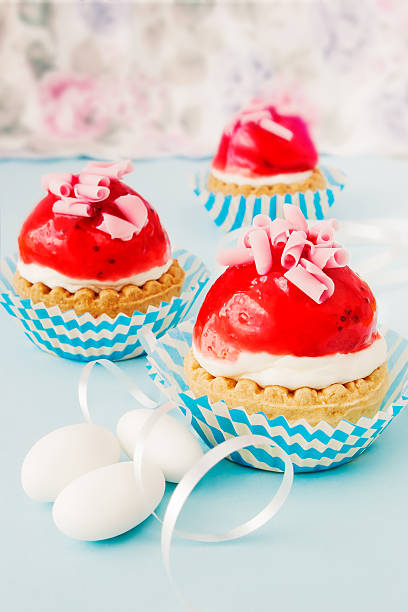 Little cupcakes with cream and strawberry glaze stock photo