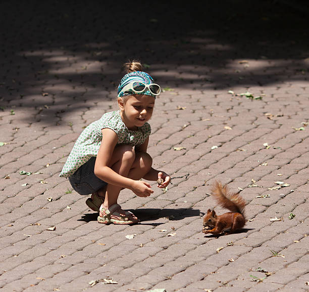 istock Little girl and squirrel 480435569
