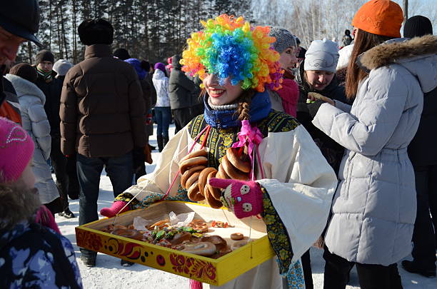Tomsk, Russia - February 26, 2012: Costumed distribute sweets and bagels on Feast of Wire Winter \