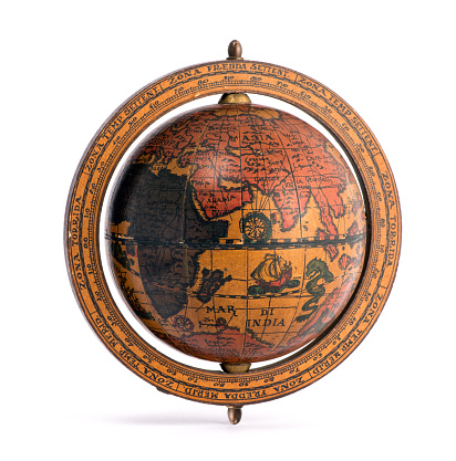 Old vintage wooden world globe showing the continents and sailing ships for planning a world tour, geography, navigation and travel isolated on white