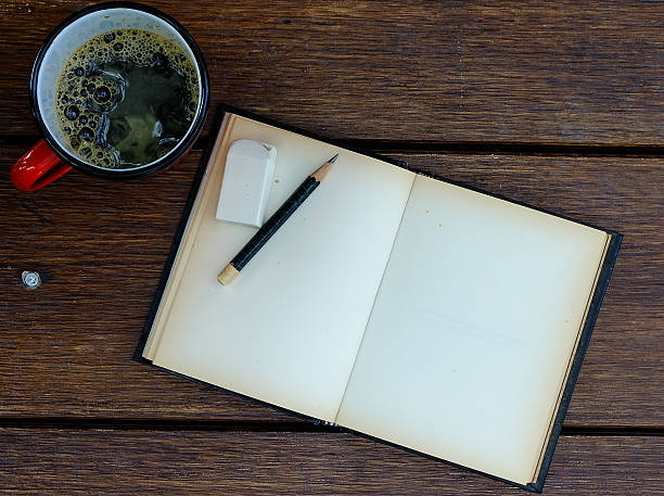 istock cup of coffee and pencil and notebook open on table 480443140
