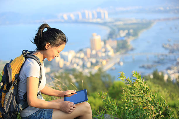 mujer joven deportiva uso tableta digital al aire libre - travel destinations mountain hiking profile fotografías e imágenes de stock