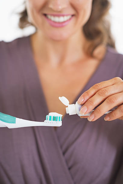 istock closeup on young woman squeezing toothpaste from tube 480447741
