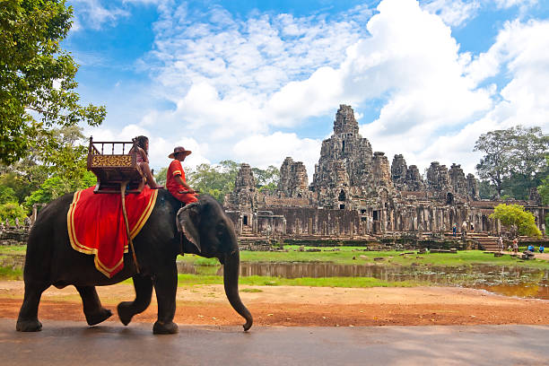 Siem Reap: Tourists ride elephants along the road around the Bayon temple at the Angkor Wat complex.