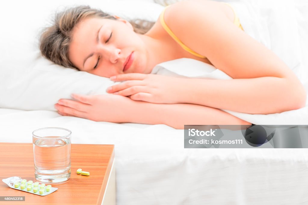 pills and a glass of water for the sick girl 2015 Stock Photo