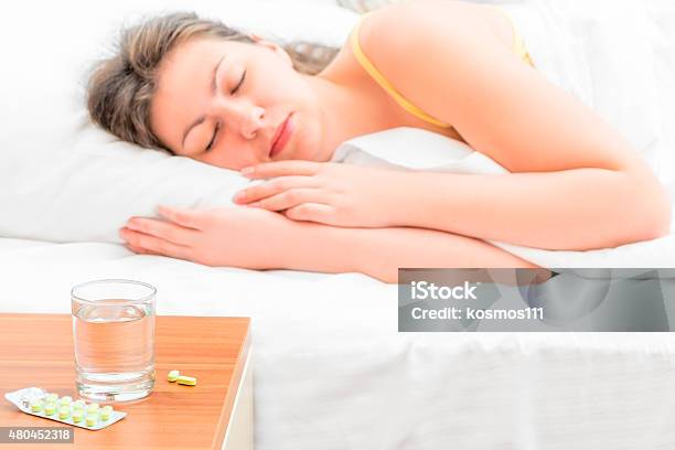 Pills And A Glass Of Water For The Sick Girl Stock Photo - Download Image Now - 2015, Adult, Adults Only