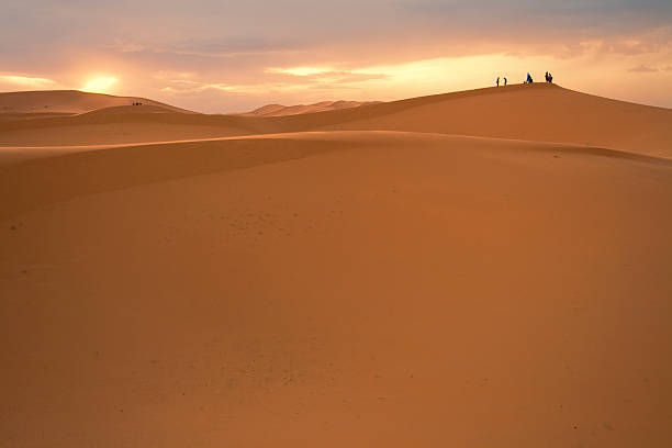 istock People Silhouetted in sunset, Sahara Desert 480453843