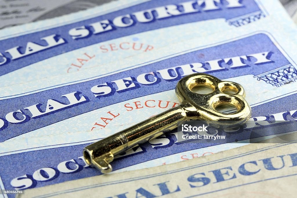 The key to social security benefits Gold key laying on social security card Social Security Card Stock Photo