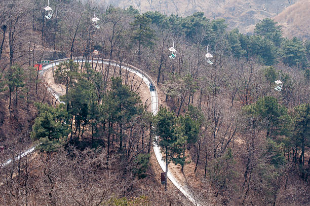 slide down from the great wall Beijing,China - March 30 ,2011 : Visitor use toboggan-run slide down in motion blur from the great wall of China at Mutianyu pass in Beijing,China.That is fast way and fun to come down. mutianyu toboggan stock pictures, royalty-free photos & images