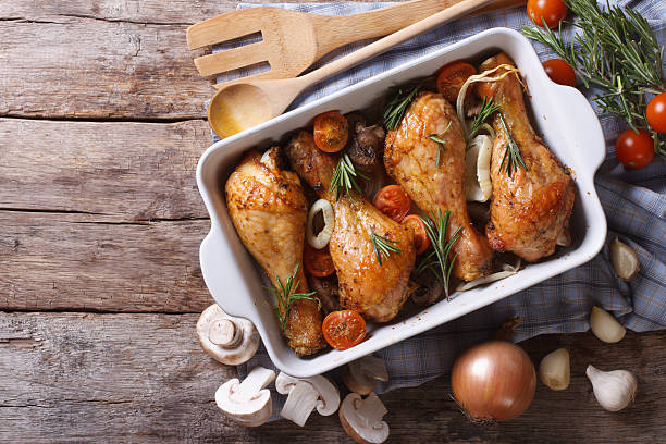 Baked chicken legs with mushrooms and vegetables. horizontal top Baked chicken legs with mushrooms and vegetables. horizontal view from above chicken stock pictures, royalty-free photos & images