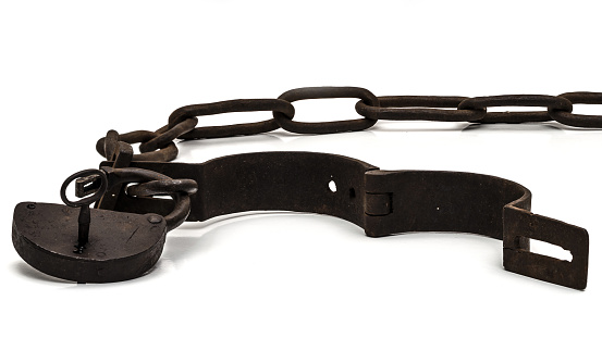 Rusty old shackles with padlock, key and open handcuff used for locking up prisoners or slaves between 1600 and 1800.