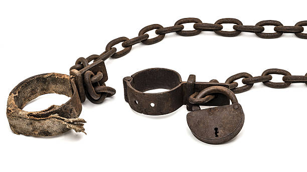 Rusty old shackles with padlock and padded shackles Rusty old shackles with padlock and padded shackles used for locking up prisoners or slaves between 1600 and 1800. dungeon medieval prison prison cell stock pictures, royalty-free photos & images