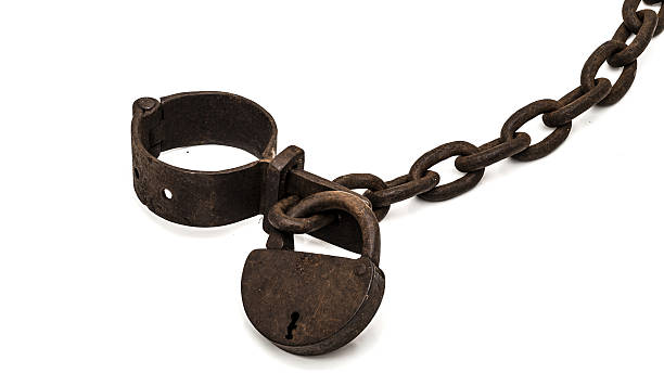 Rusty old shackles with padlock Rusty old shackles with padlock used for locking up prisoners or slaves between 1600 and 1800. dungeon medieval prison prison cell stock pictures, royalty-free photos & images
